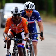 Two cyclists are pictured during a race, making a huge amount of effort.